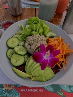 a white bowl filled with lots of different types of food on top of a table