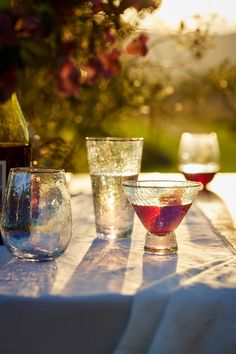 four glasses and a bottle sitting on a table