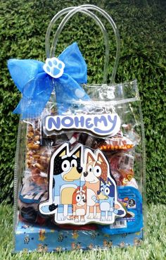 a plastic bag with cartoon characters on it and a blue ribbon tied around the handle