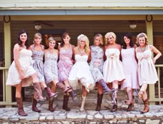 a group of women standing next to each other in front of a wooden building with stone steps