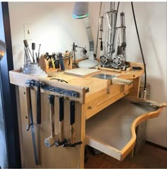 a workbench with many tools hanging from it's sides and on the wall