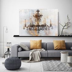 a living room filled with furniture and a chandelier hanging from the wall above it