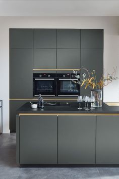 a kitchen with gray cabinets and black counter tops