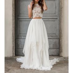 a woman standing in front of a door wearing a white dress