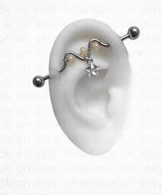 an ear with two balls and a star on the end, sitting in front of a white background