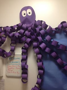 an octopus made out of purple ribbon on the wall