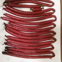 a bunch of red beans sitting on top of a wooden table