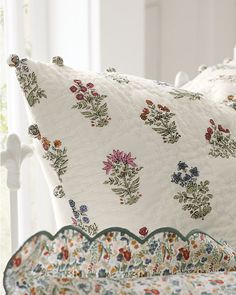 a white bed topped with lots of pillows