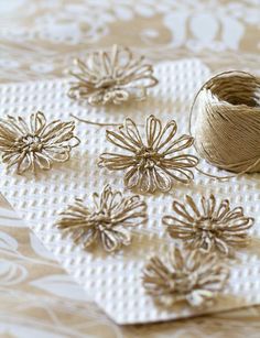 several spools of thread sitting on top of a table next to some flowers