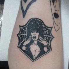 a woman's arm with tattoos on it and an image of a spider web