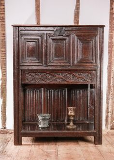 an old wooden cabinet with two buckets on it