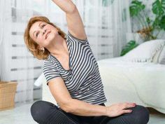 a woman sitting on the floor with her arms in the air