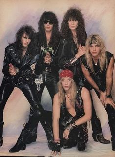 the band kiss posing for a photo in black leather outfits and headbands, with their arms around each other