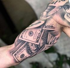 a man's arm covered in money and tattoos