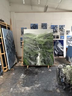 an artist's studio with several paintings on easels