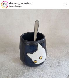 a ceramic cup with a spoon in it