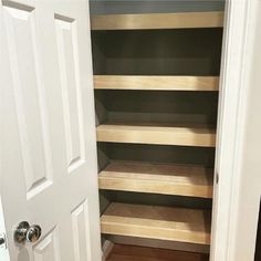 an empty closet with wooden shelves in it