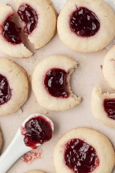 cookies with jam on them and a spoon