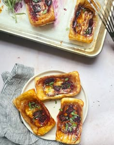 small pastries sitting on top of a white plate next to a baking pan filled with food