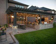 an outdoor kitchen and dining area is lit up at night