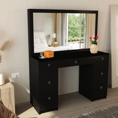 a black vanity table with a mirror and vase on the top, in front of a window