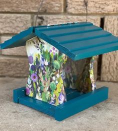 a blue birdhouse with flowers painted on it