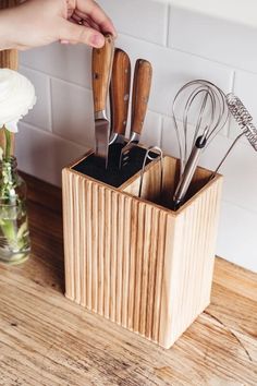 a wooden holder with utensils in it