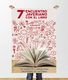 an open book sitting on top of a wooden floor next to a poster that says 7 encuentro javeranoo con el libro