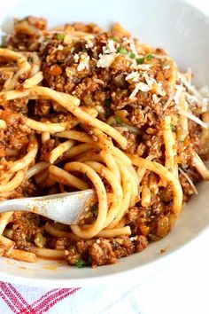 a white bowl filled with spaghetti and meat