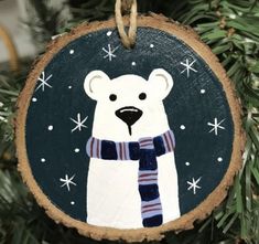 a wooden ornament with a polar bear wearing a scarf on it's neck