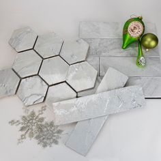 marble tiles and ornaments on a white countertop with green ornament, silver bauben