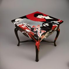 an artisticly painted stool with a woman's face on the top and sides