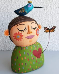 a small doll with a bird on top of it