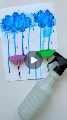 a bottle with some umbrellas on it next to a paper cutout that says rain