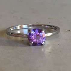 "A TINY round-shape faceted genuine Purple Amethyst hand set in a 4-prong setting featuring a tapered sterling silver shank. This beauty makes a great birthstone ring for those February Birthday gals or a lovely stackable ring for her! Wrapped in a box ready for gift-giving. (r-egt-146) Ring info ------------------------- Genuine Purple Amethyst measures 5mm Sterling Silver *Follow us @belesasjewelry on Instagram for promotions/giveaways *LIKE* us on Facebook http://www.facebook.com/Belesas to f Modern Crystal Ring With Prong Setting, Modern Solitaire Crystal Ring, Modern Round Crystal Gemstone Ring, Faceted Crystal Promise Ring In Fine Jewelry Style, Amethyst Birthstone Ring With Round Cut, Faceted Round Gemstones For Fine Jewelry, White Gold Crystal Birthstone Ring, Purple Round Cut Birthstone Ring With Center Stone, Faceted Gemstones Fine Jewelry