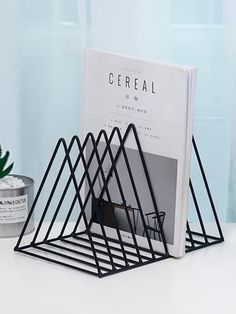 a magazine rack sitting on top of a white table next to a potted plant