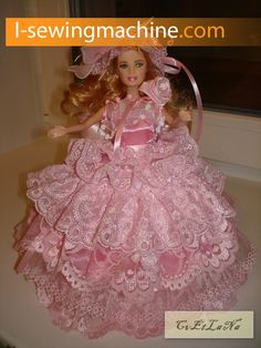 the doll is wearing a pink dress and hat