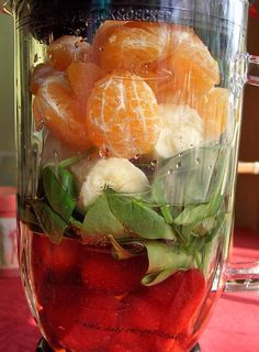 a blender filled with fruit and vegetables on top of a red tableclothed surface