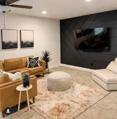 a living room filled with furniture and a flat screen tv mounted to the side of a wall