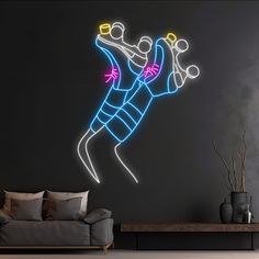 a living room with a couch, table and neon light painting on the wall above it