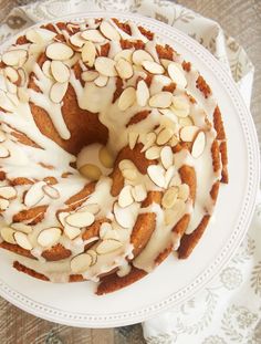 a bundt cake with white frosting and almonds