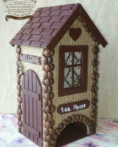 a small house made out of wood and decorated with chocolates on the outside, sitting on a table