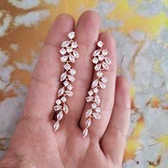 a pair of earrings in the palm of someone's hand