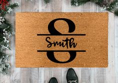 a door mat with the word smith and two on it, surrounded by christmas decorations