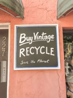 a sign that says buy vintage recycle save the planet on a pink building