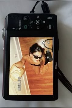 a cell phone with an image of a woman wearing sunglasses and holding a tennis racquet