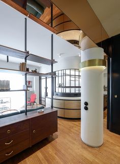 a large white cylinder sitting in the middle of a room next to a wooden floor