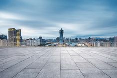 an empty concrete floor with the city skyline in the background