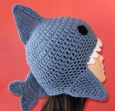 a crocheted hat with a shark on it's side and an open mouth