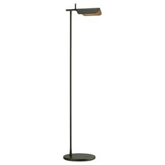 a floor lamp with a black base and a brown shade on the top, standing upright